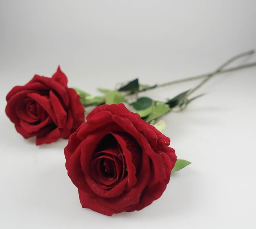 Realistic artificial red roses laid flat – elegant floral décor