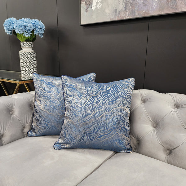 Atlantis Blue Designer Cushions styled on grey sofa, modern wave design with gold highlights
