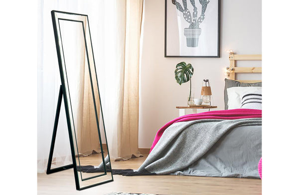 Free standing black beaded framed mirror styled in bedroom with modern décor.
