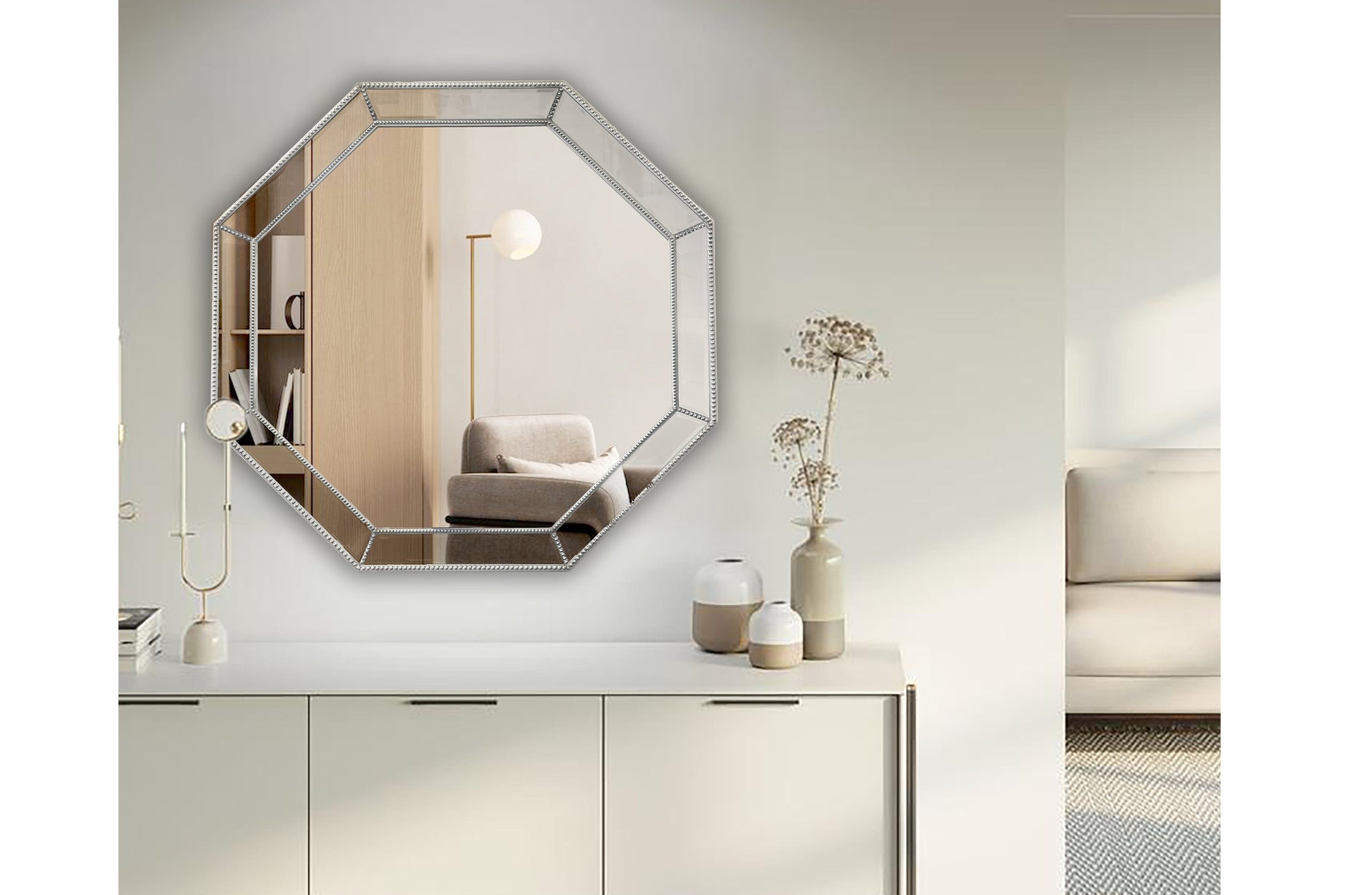 Octagon silver beaded framed mirror styled above console in minimalist living room.
