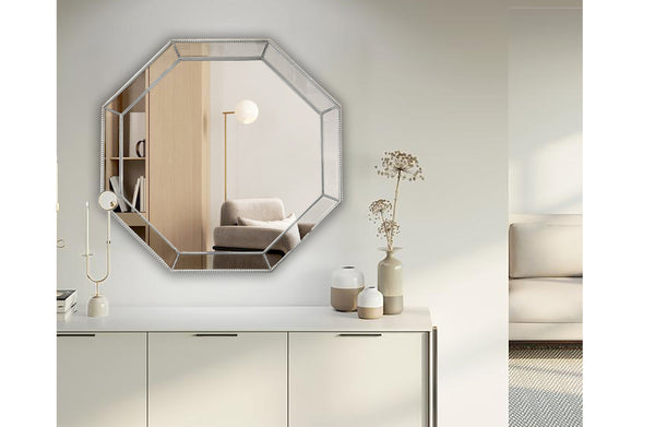 Octagon silver beaded framed mirror styled above console in minimalist living room.