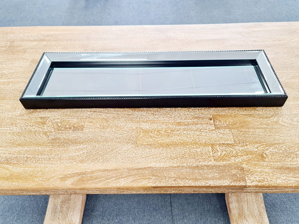 Modern black beaded mirror tray on wooden table – elegant & stylish.