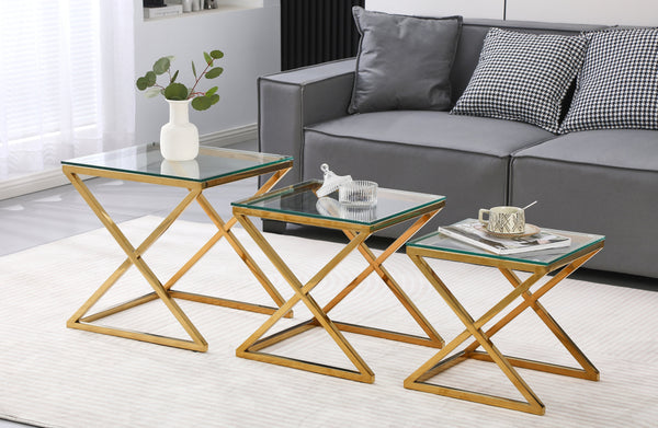 Bella set of three nesting side tables with polished gold frame and clear glass tops in lounge.