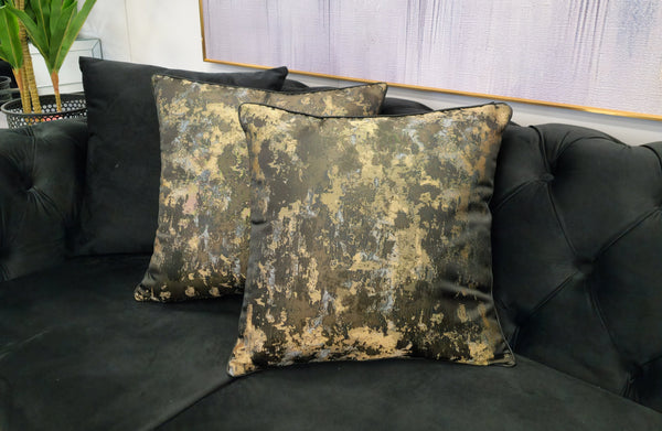Black designer cushion with abstract gold pattern, adds luxe flair to sofas or lounge chairs
