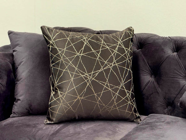 Black designer cushion with metallic gold stitched geometric pattern, perfect for sofas and lounge chairs