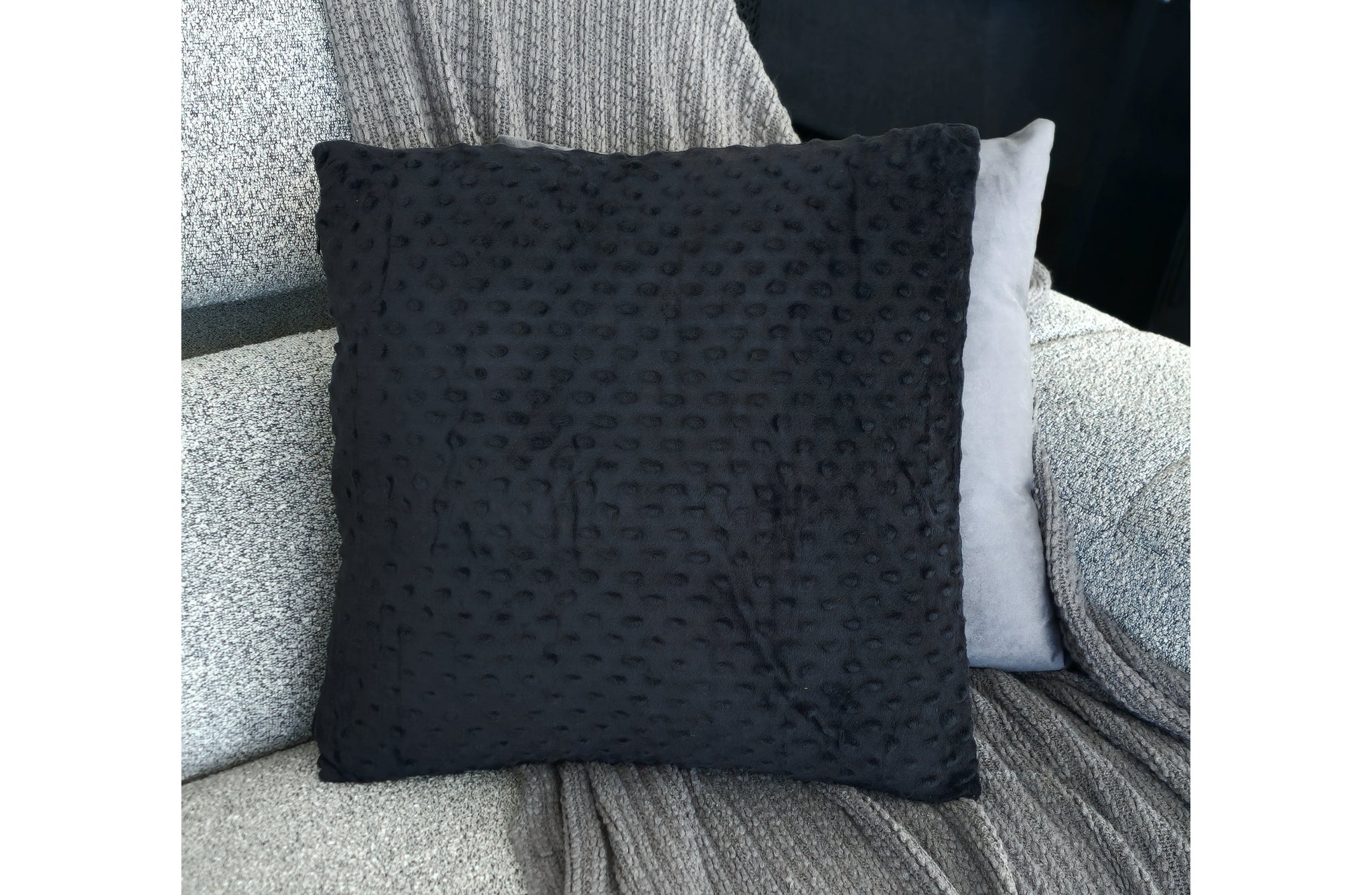 Black velvet designer cushion with raised bubble texture, perfect for adding soft luxury to sofas and beds
