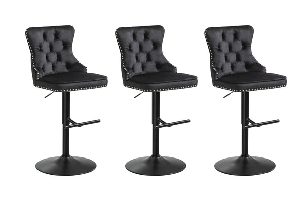 Set of three black velvet tufted swivel bar stools with stud trim and matte black base.