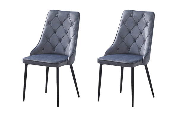 Set of 2 grey velvet button tufted dining chairs with black legs in studio photography.