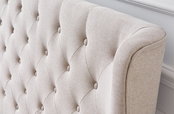 Close-up of Cambridge Bed tufted headboard in soft tan beige linen fabric.