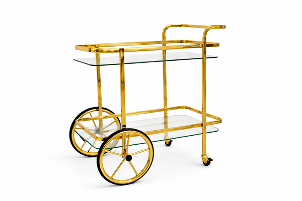 Elegant gold drink trolley with clear glass shelves creating light airy modern entertaining space