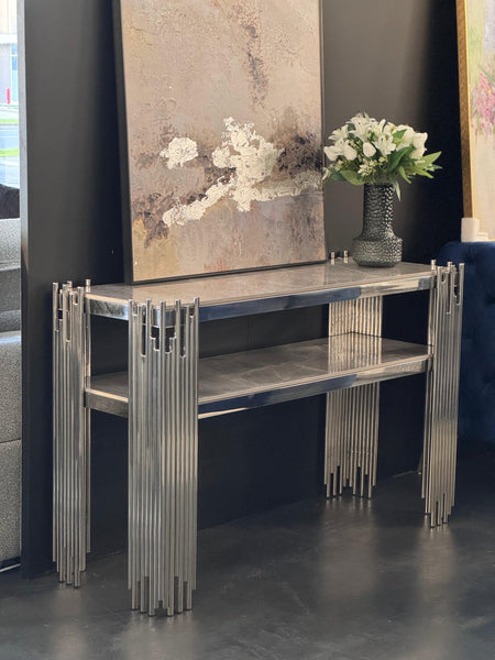Chelsea console table with polished silver frame and grey marble top styled with décor.