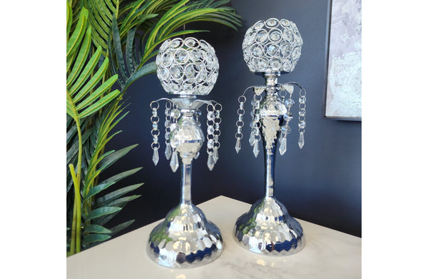 Stylish silver crystal ball candle holders with hanging crystals, displayed on a white marble surface — perfect for adding elegance to any interior setting.