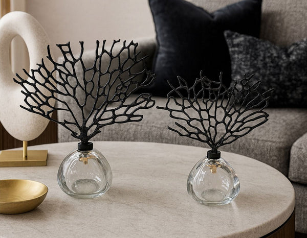Decorative black crystal tree set on glass bases with a neutral background