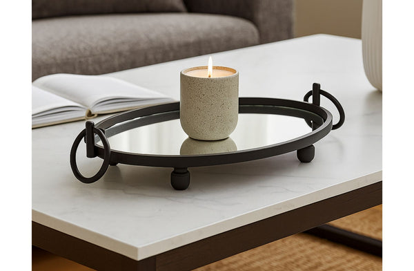 Decorative black metal mirrored tray with a candle on a coffee table