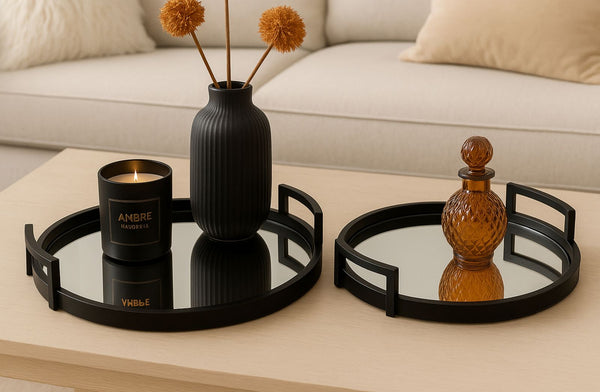 Decorative black mirrored metal tray including a black vase, candle, and mirrors on a coffee table.