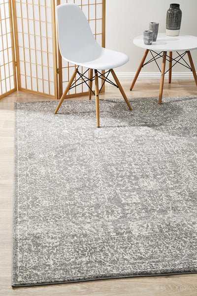 Evoke 256 Grey rectangular rug styled in a modern living space with white chair and table