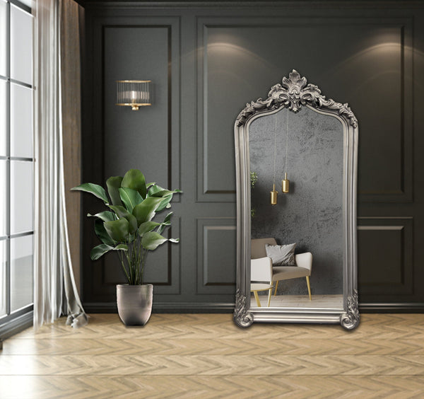 Antique silver French Provincial arch mirror styled in luxury interior with plant