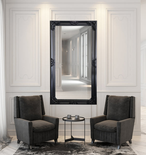 Black French provincial deluxe mirror styled vertically with two armchairs and coffee table décor.