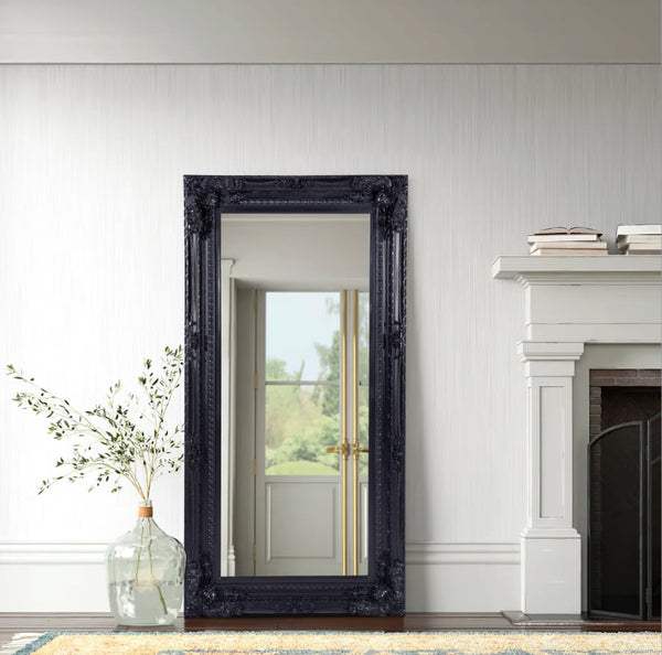 Black French provincial LUX ornate mirror styled beside white fireplace and large glass vase.