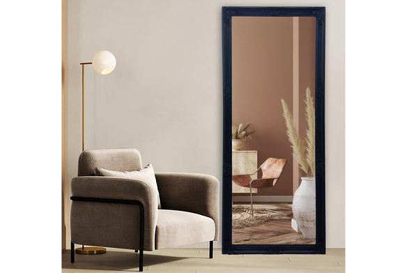 Black French provincial ornate mirror styled with beige armchair, floor lamp and earthy décor accents.