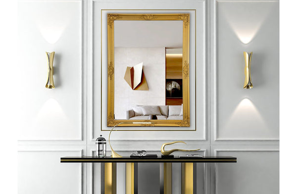 Black French provincial ornate mirror styled horizontally above console with vases and décor.