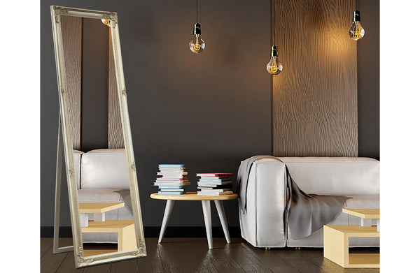 Champagne French provincial free standing mirror styled with white sofa, books and warm lighting.