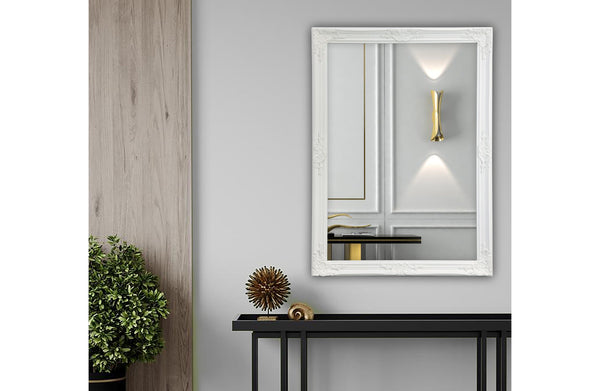 White French provincial ornate mirror styled on wall with black console and gold décor.