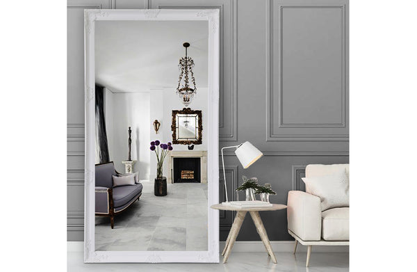 White French provincial ornate mirror styled in living room with chandelier and grey walls.