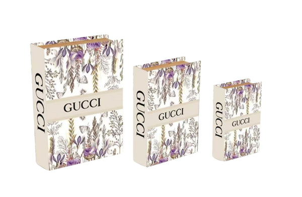 Set of floral designer faux book storage boxes in small medium and large sizes with white and purple bloom pattern.