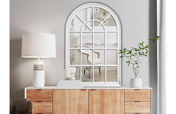 Small white Hampton’s Arch Window Style Mirror styled above wooden sideboard