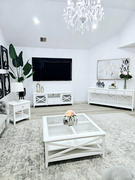 Hampton’s style white coffee table with glass top styled in elegant full living room view.