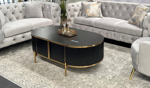 Kingsley black coffee table with gold trim styled in living room