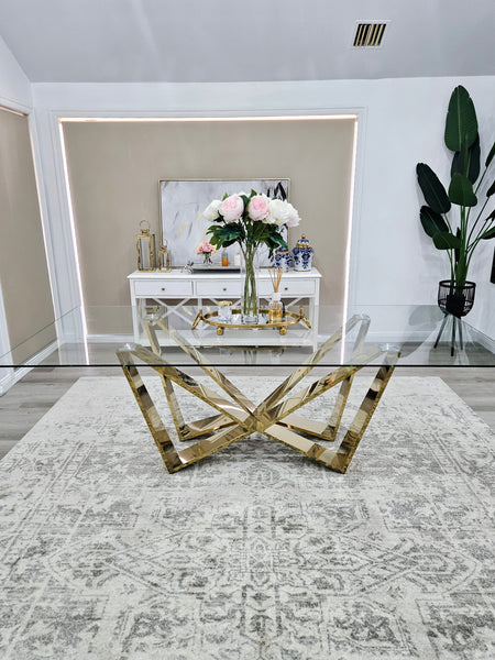 Lenox Dining Table in polished gold frame with clear glass top styled beautifully.