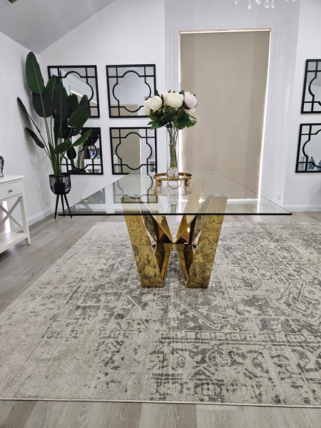 Lenox Dining Table gold frame with clear tempered glass top styled in elegant setting.