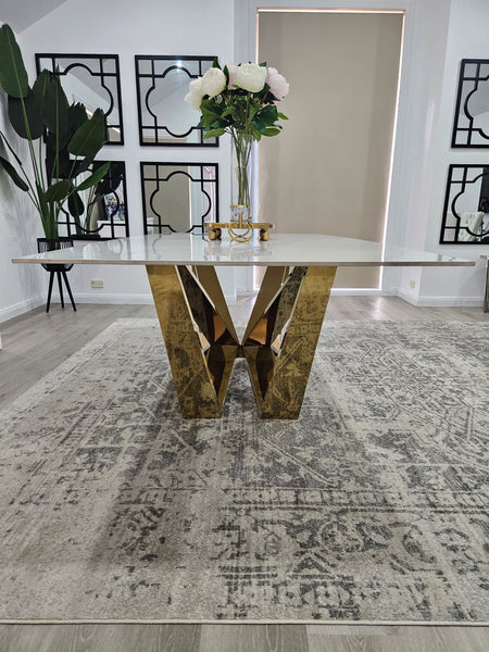Lenox Dining Table with gold stainless frame and marble top styled with floral décor.