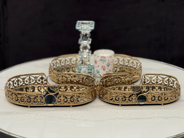 Elegant gold Lucy trays styled with candles and décor on a marble table, showcasing their ornamental charm.