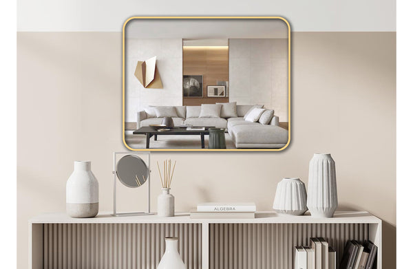 Gold metal rectangle wall mirror styled above console table with modern décor