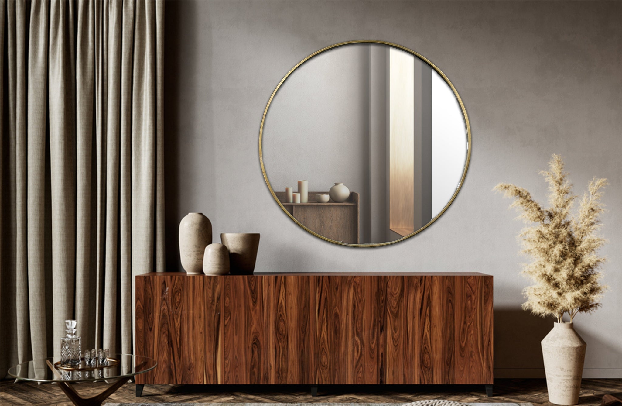 Large gold round mirror styled above wooden sideboard in modern living room