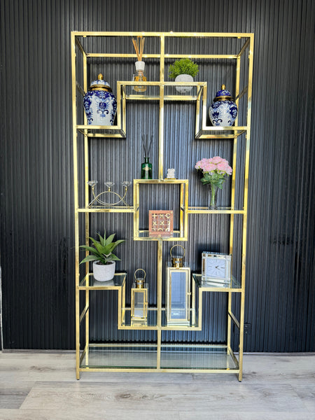 Gold Nelson Bookcase styled with decorative jars, plants, books, and lanterns – a luxurious shelving unit showcasing elegant home décor arrangements.