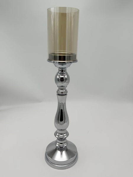 Large silver pillar candle holder with reflective finish and glass cylinder top, ideal for elegant home décor settings
