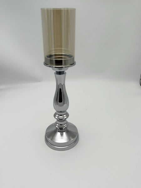 Small silver pillar candle holder with a polished metal base and glass cover, perfect for compact decorative accents