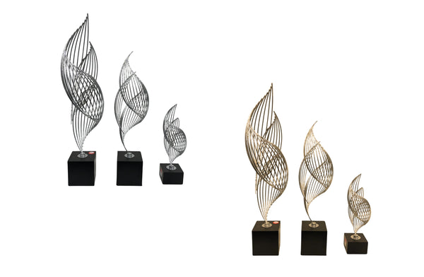 Set of 3 Ribbon Table Décor sculptures in black and gold, and black and silver finishes — featuring sleek, twisted metal design on black bases in small, medium, and large sizes.