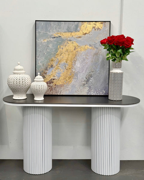 Ripple console table styled with artwork, flowers, and ceramic décor pieces.