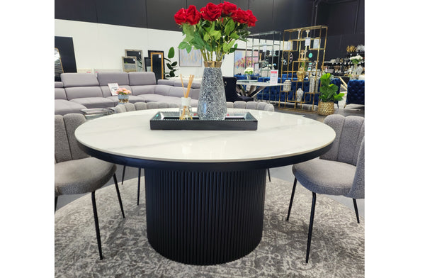 Ripple Round Dining Table styled with white marble top, ribbed base, and floral décor.