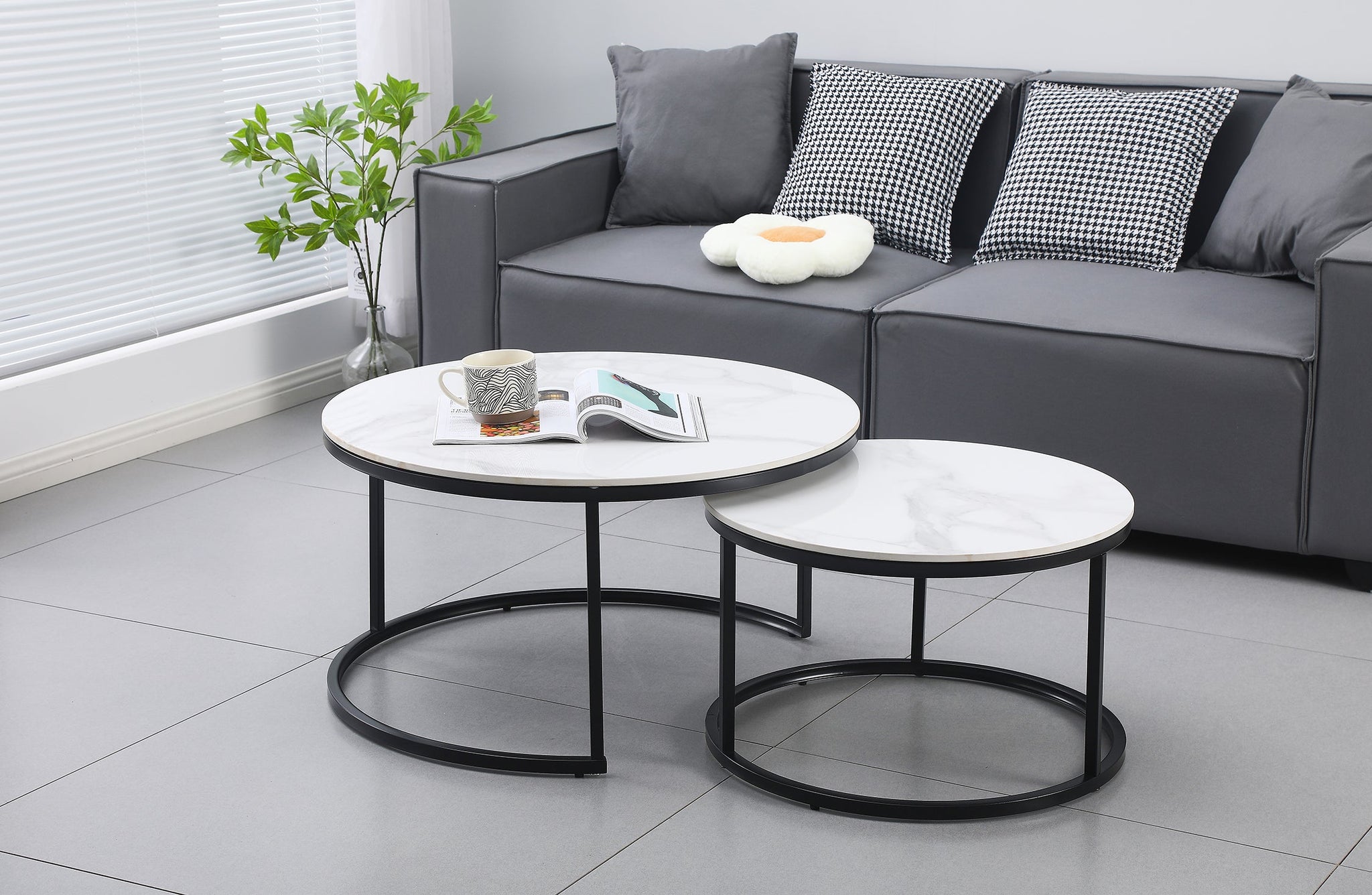 Romana nesting coffee tables in black frame with marble tops styled in a modern living room.