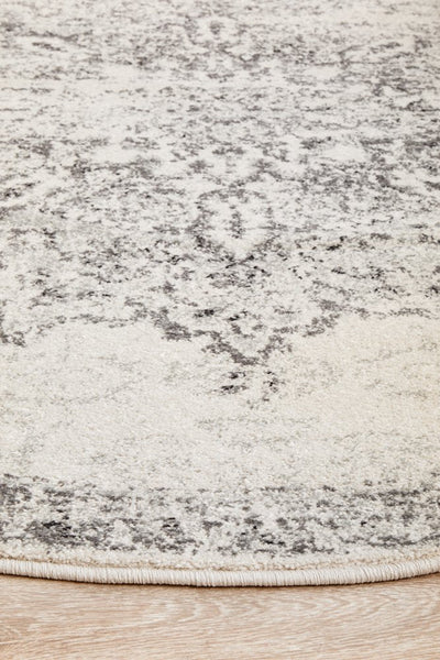 Close-up of round silver rug showing soft textured weave and detailed grey patterns.