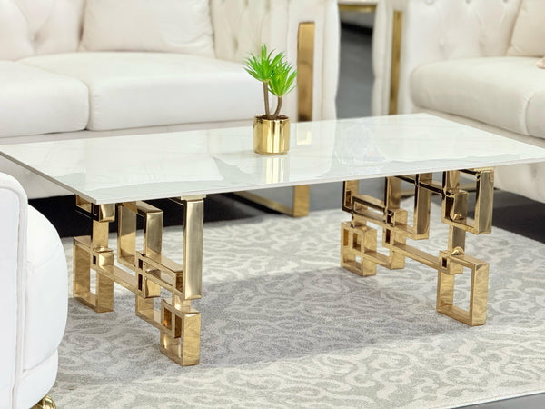 Royale gold coffee table with white marble stone top styled with elegant white sofas.