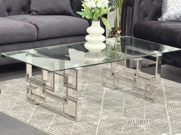Royale silver frame coffee table with clear glass top styled with black lounge suite.
