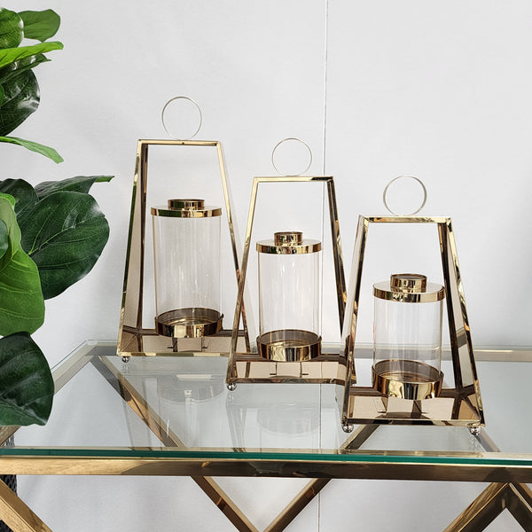 Gold tear-shaped lantern set displayed on glass table – modern and luxurious design
