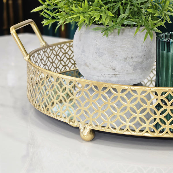 Intricate gold tray design with mirrored base and round handles.